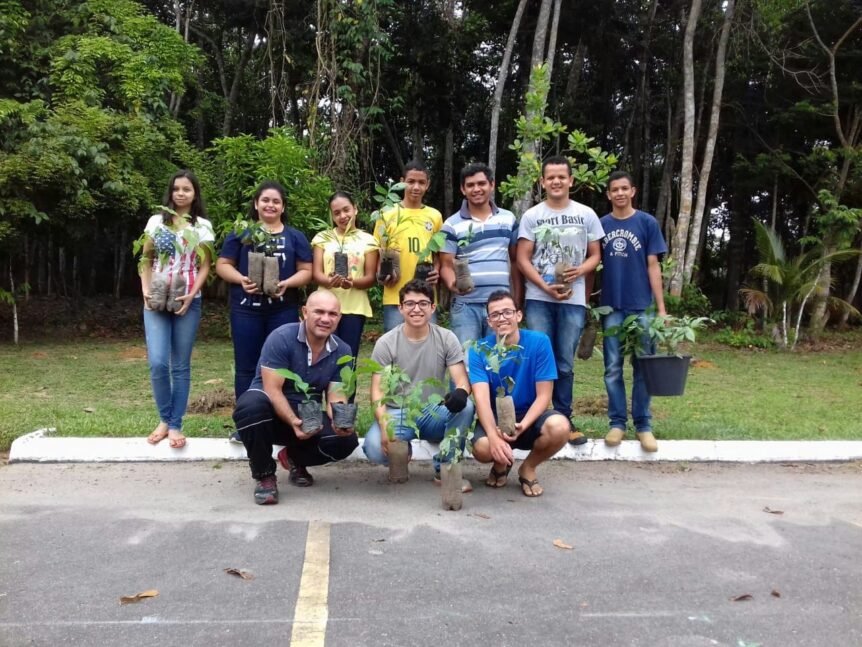 Jovens plantam árvores frutíferas